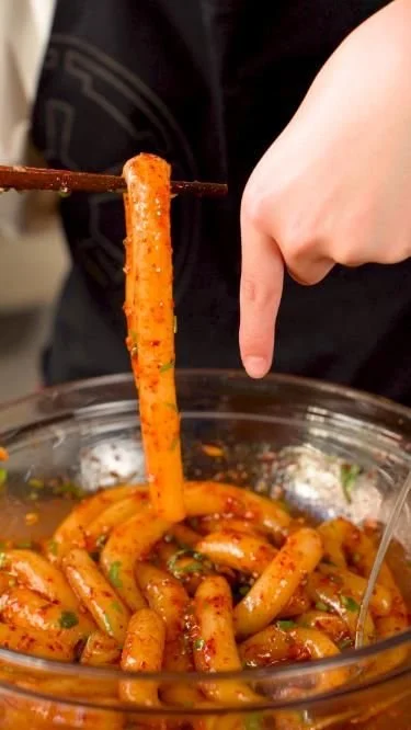 Delicious spicy potato noodles served in a bowl with garnishes.